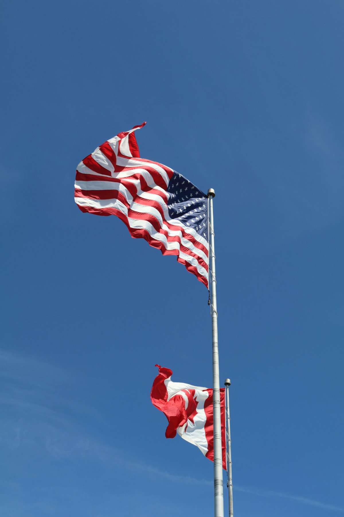 USA and Canada flag fly next to eachother